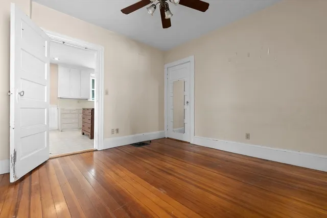 a view of empty room with wooden floor