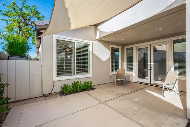 a view of a patio with table and chairs potted plants and palm trees