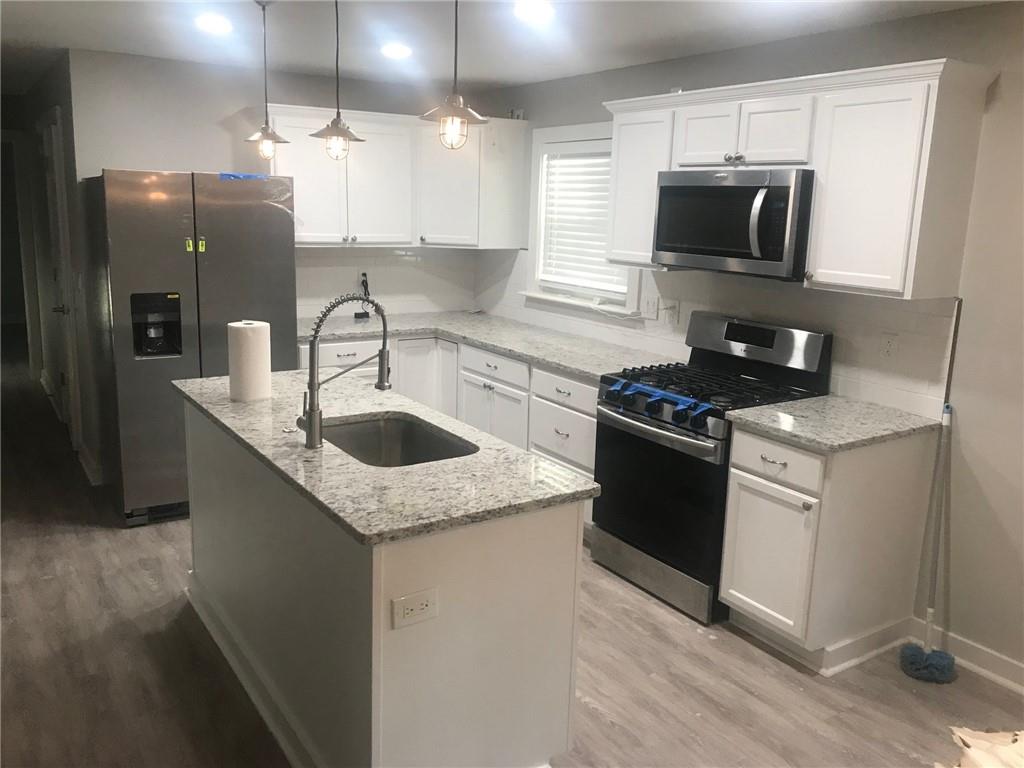 131 Fox Place Canton, GA 30114 - Photo 5 of 29 a kitchen with stainless steel appliances granite countertop a sink stove and refrigerator