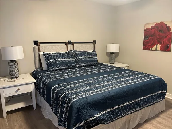 a bedroom with a bed and a lamp on dresser