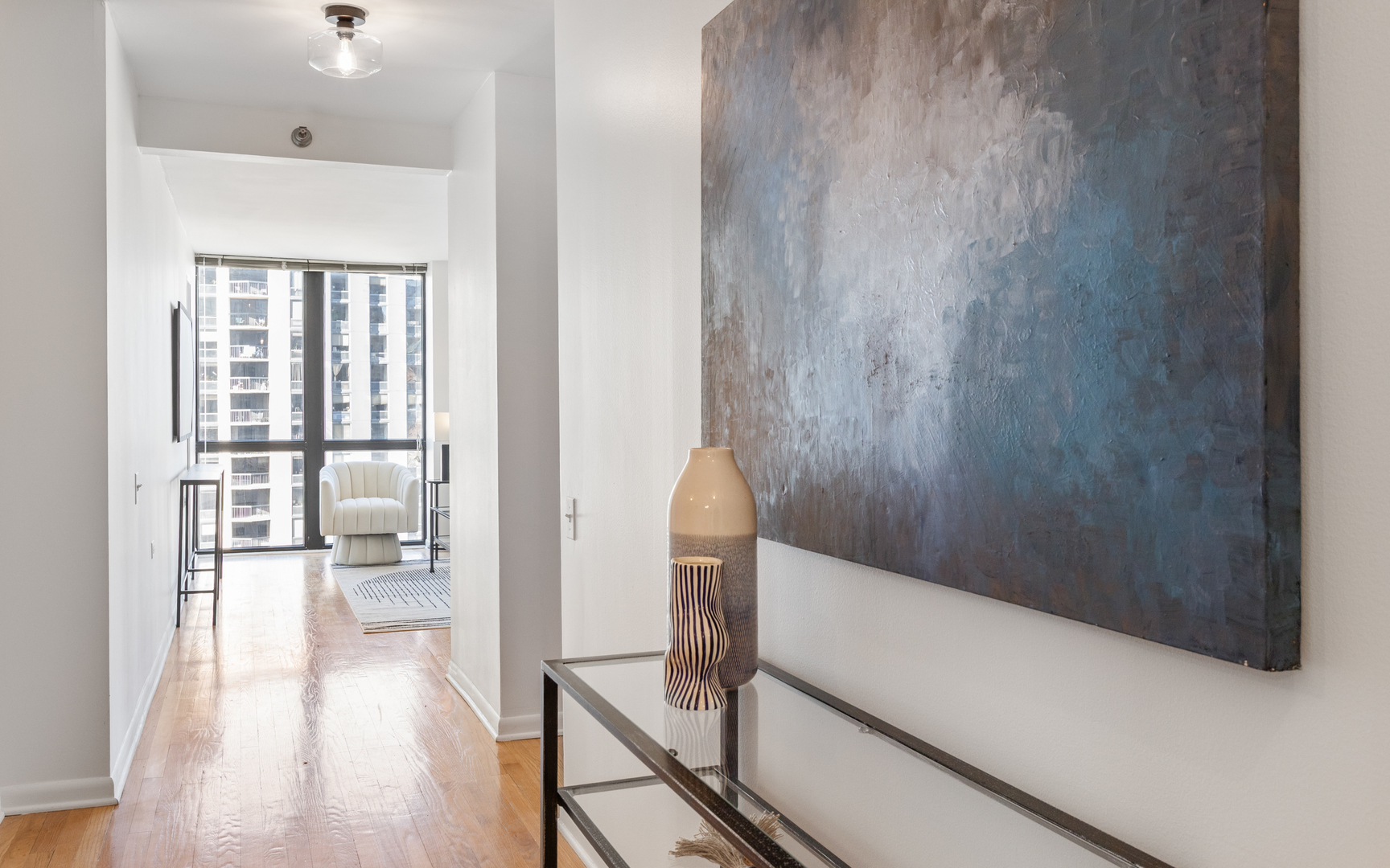 1122 North Clark Street, Unit 1203 Chicago, IL 60610 - Photo 6 of 22 a view of a hallway with bathroom and wooden floor