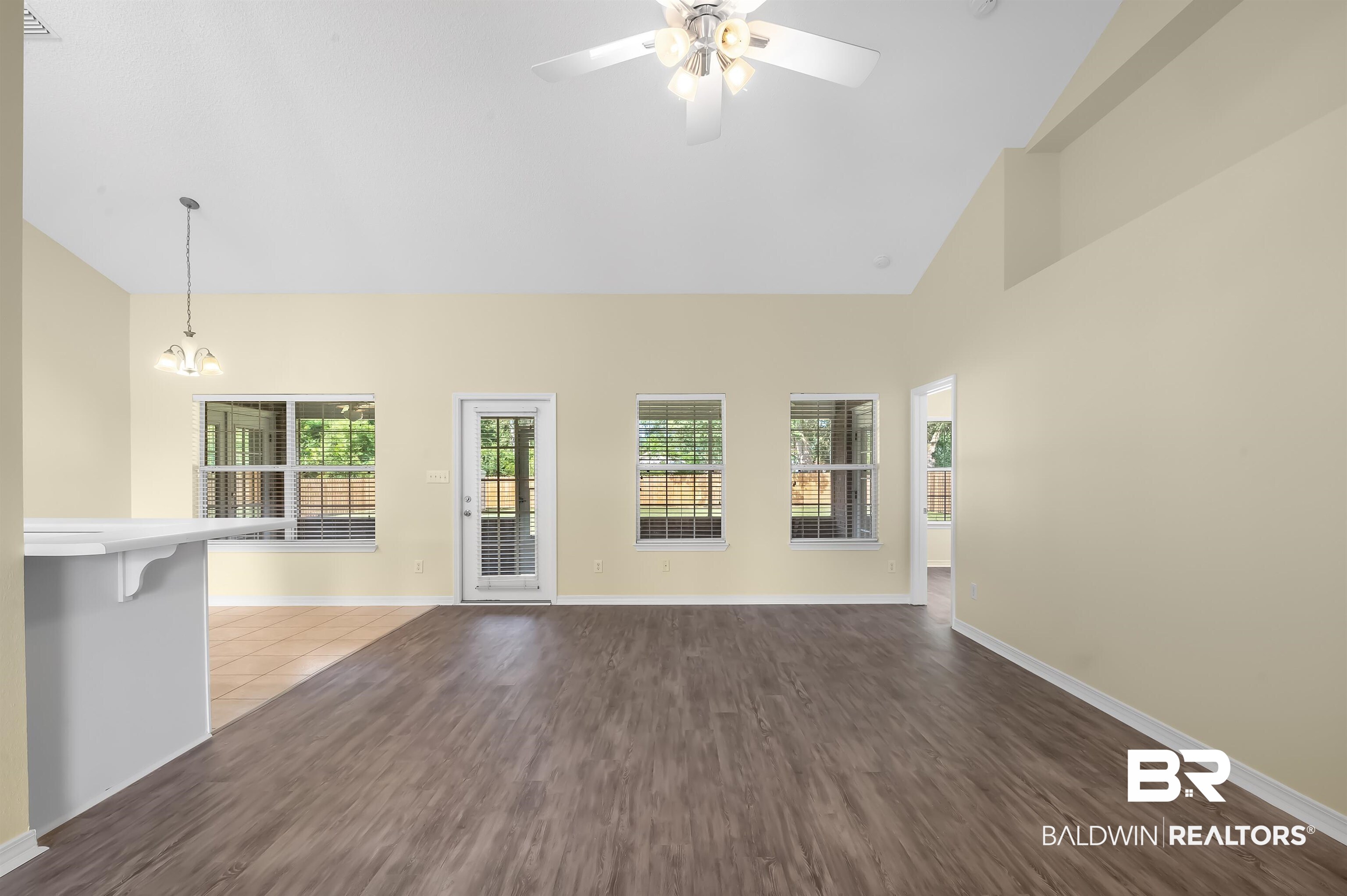 12443 Venice Boulevard Foley, AL 36535 - Photo 21 of 59 Unfurnished living room featuring high vaulted ceiling, ceiling fan with notable chandelier, and dark hardwood / wood-style flooring