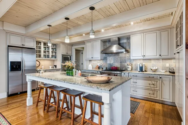 a kitchen with stainless steel appliances granite countertop lots of counter top space and wooden floor
