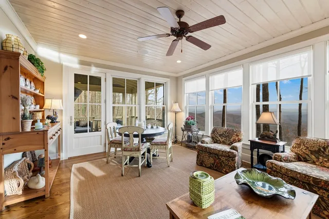 a kitchen with stainless steel appliances granite countertop a stove a refrigerator a dining table and chairs with wooden floor