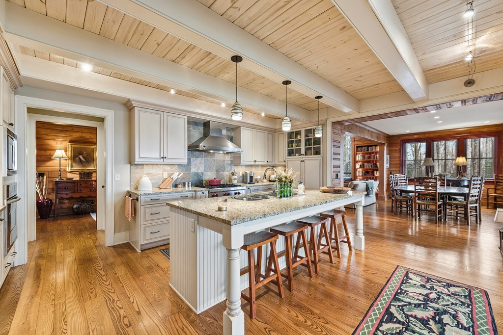 1115 Outlook Road Murphy, NC 28906 - Photo 19 of 60 a kitchen with stainless steel appliances granite countertop a stove a refrigerator a dining table and chairs with wooden floor
