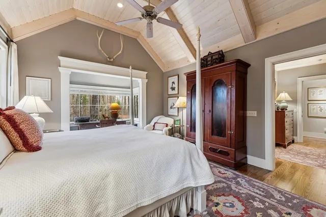 a bedroom with a bed couch and windows