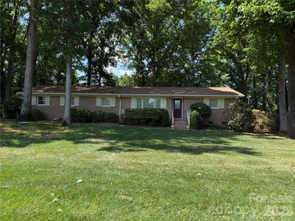 a front view of a house with a yard and green space