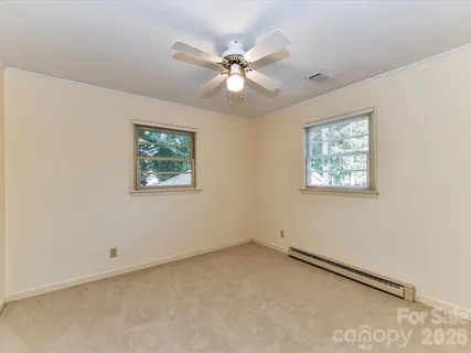 an empty room with window and ceiling fan