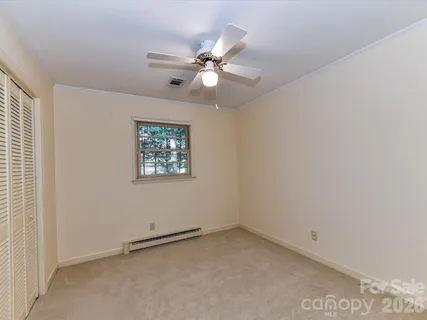 an empty room with a window and a fan