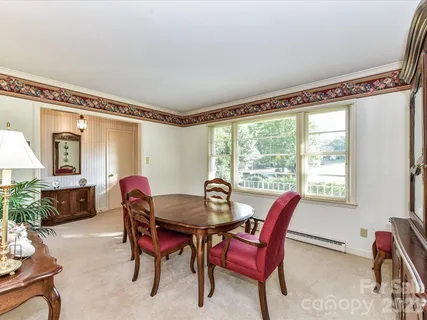 a dining room with furniture window and wooden floor