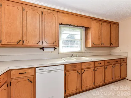 a kitchen with stainless steel appliances granite countertop wooden cabinets a sink and a window