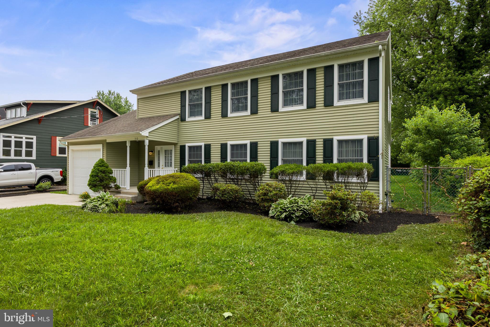 310 South Washington Avenue Moorestown, NJ 08057 - Photo 2 of 37 a front view of a house with a garden and porch