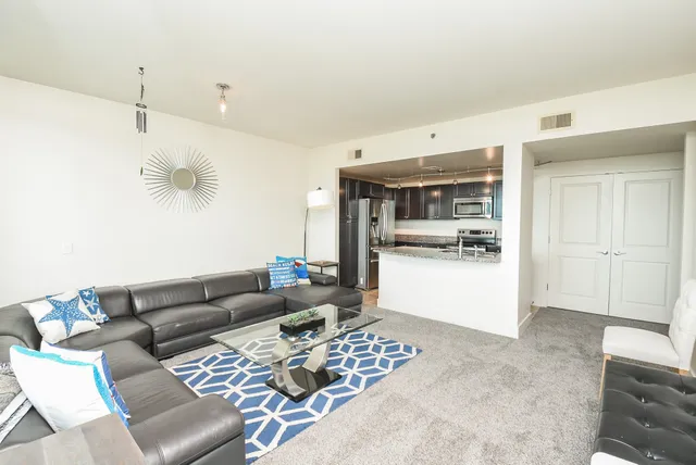 a living room with furniture and kitchen view