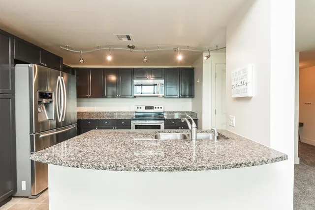 a kitchen with a center island and stainless steel appliances