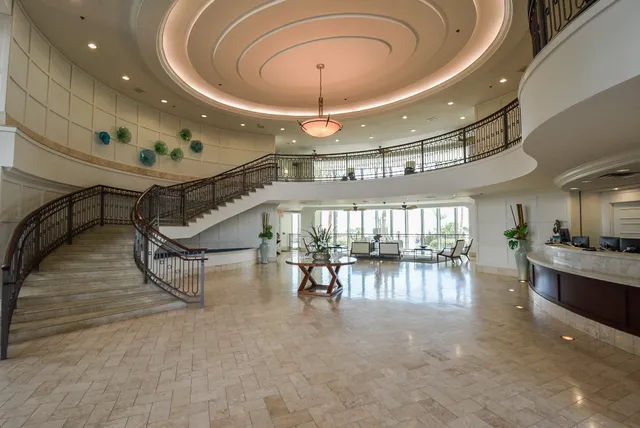 a gym room with lots of furniture and a chandelier