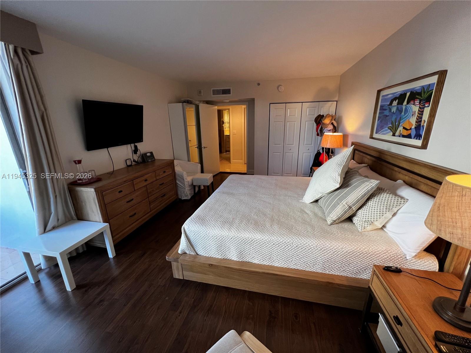 19707 Turnberry Way, Unit 4L Aventura, FL 33180 - Photo 14 of 40 a bedroom with a bed and a flat screen tv