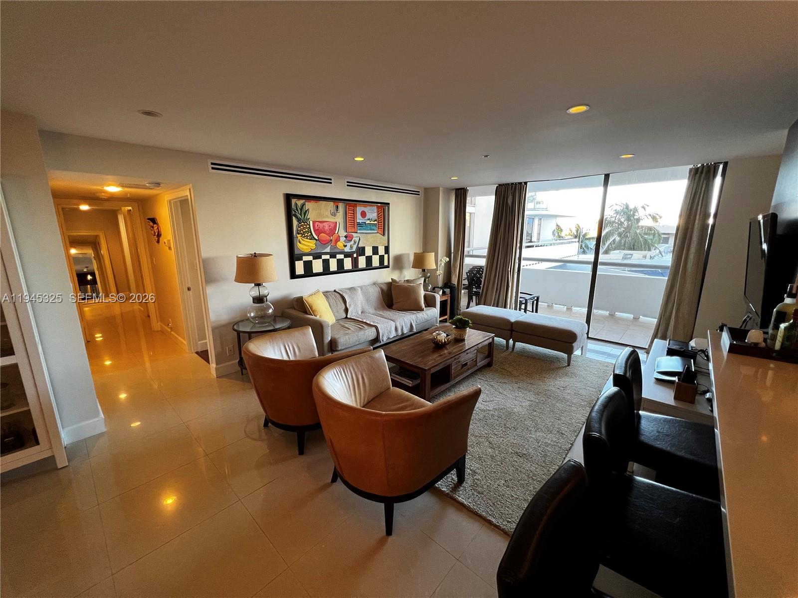 19707 Turnberry Way, Unit 4L Aventura, FL 33180 - Photo 2 of 40 a living room with furniture a flat screen tv and a large window
