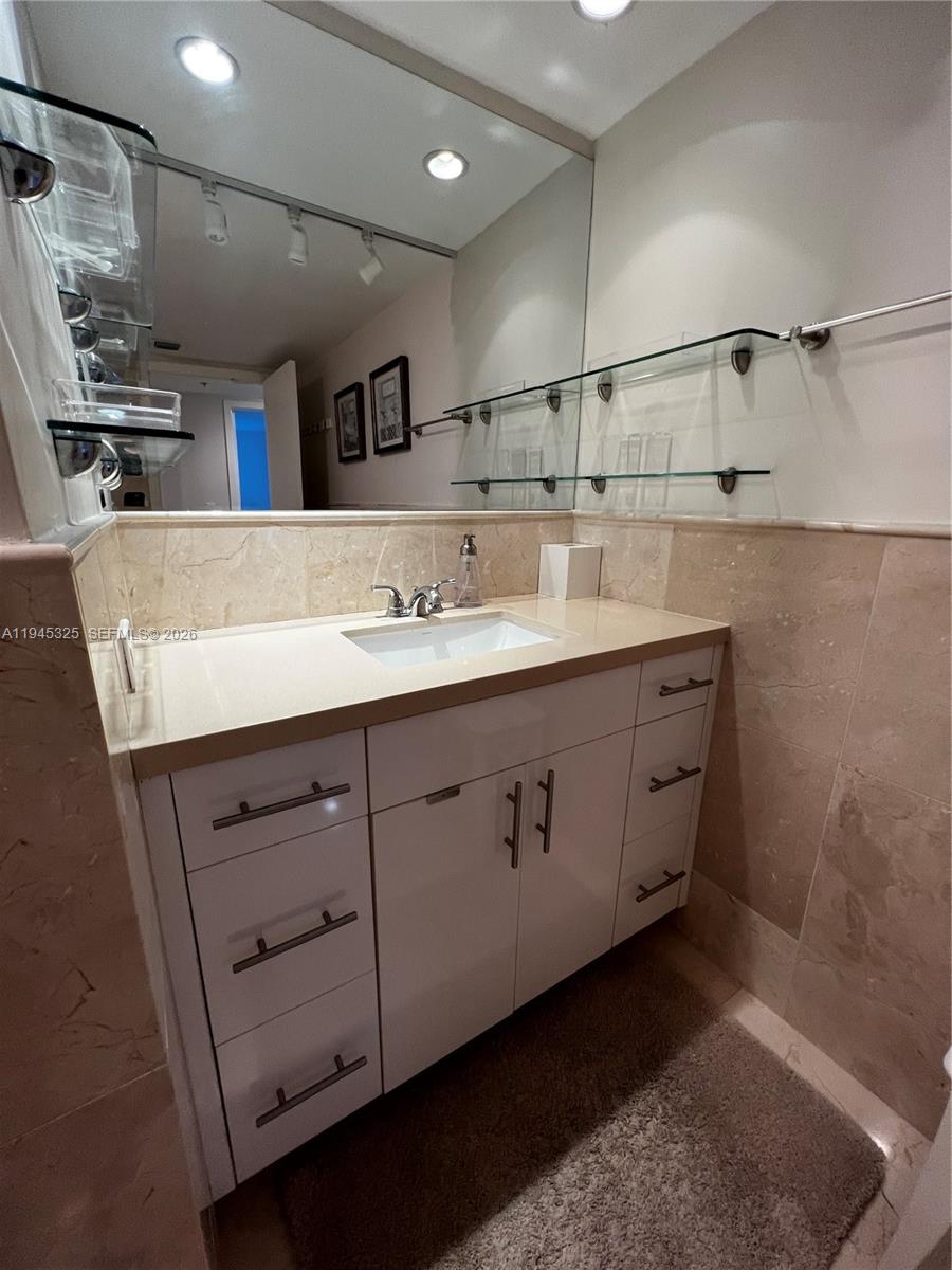 19707 Turnberry Way, Unit 4L Aventura, FL 33180 - Photo 23 of 40 a bathroom with a sink a vanity and a mirror