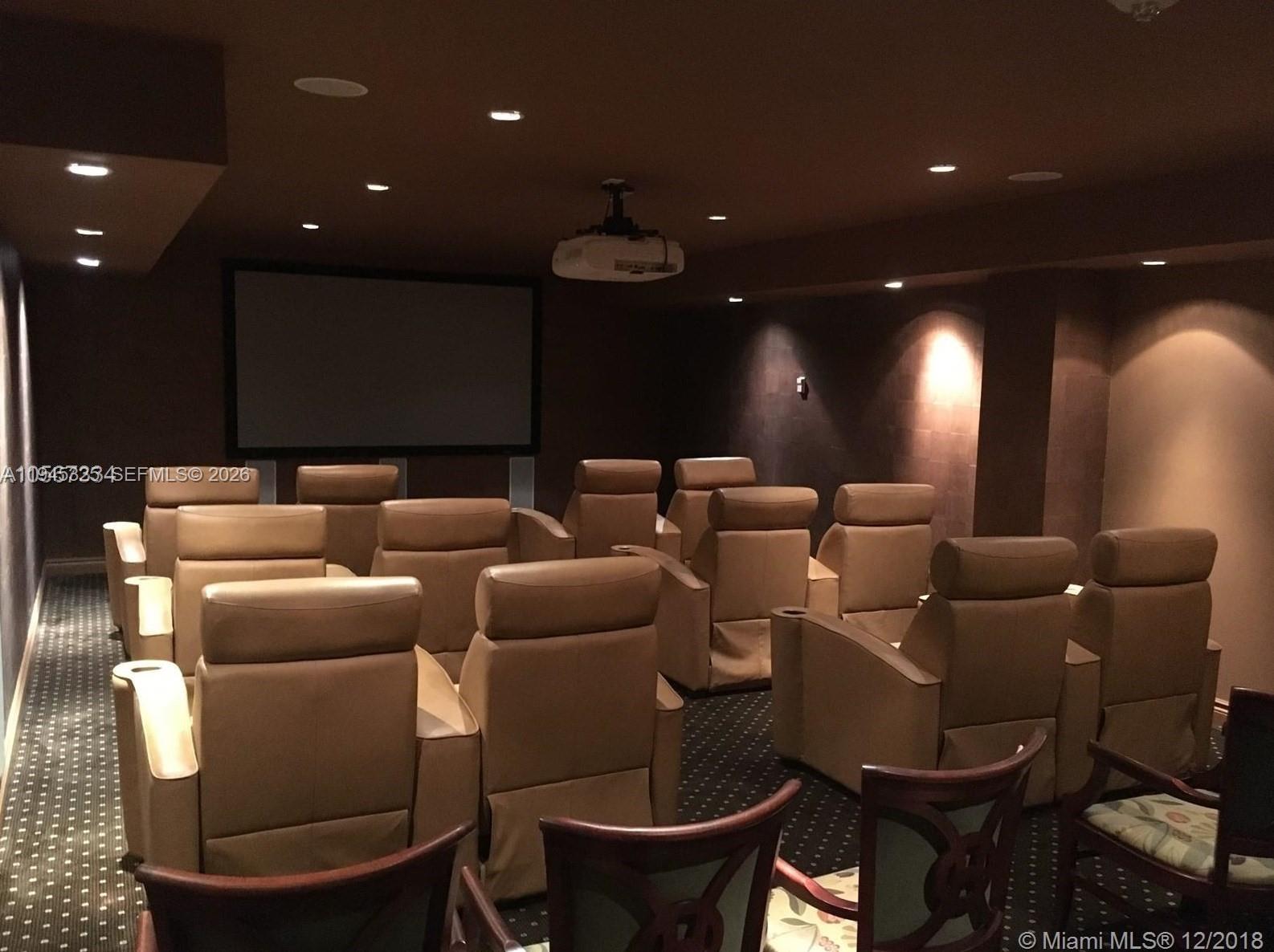 19707 Turnberry Way, Unit 4L Aventura, FL 33180 - Photo 40 of 40 a media room with lots of chairs and a projector screen