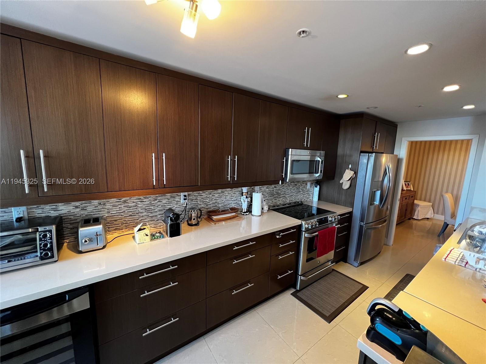 19707 Turnberry Way, Unit 4L Aventura, FL 33180 - Photo 7 of 40 a kitchen with a sink appliances and cabinets