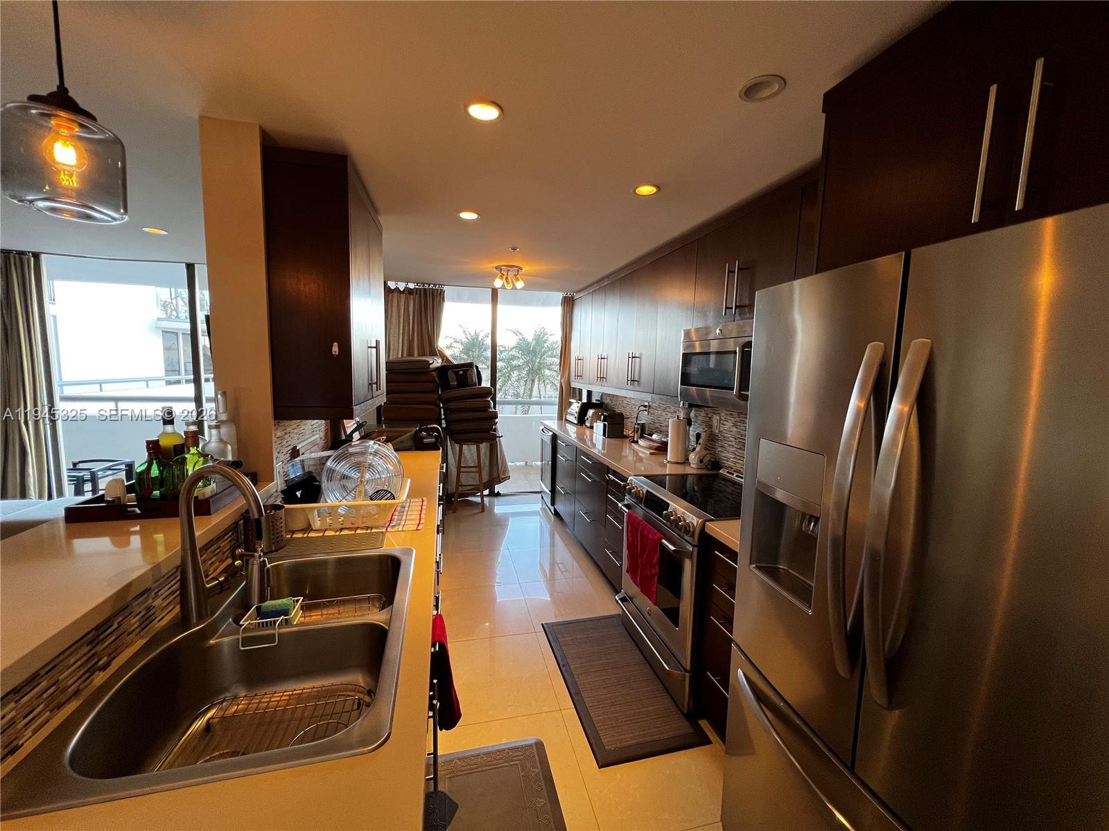 19707 Turnberry Way, Unit 4L Aventura, FL 33180 - Photo 9 of 40 a kitchen with refrigerator and sink