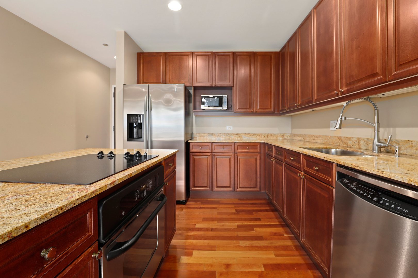 737 West Washington Boulevard, Unit 710 Chicago, IL 60661 - Photo 5 of 28 a kitchen with stainless steel appliances granite countertop wooden cabinets a stove top oven a sink and dishwasher