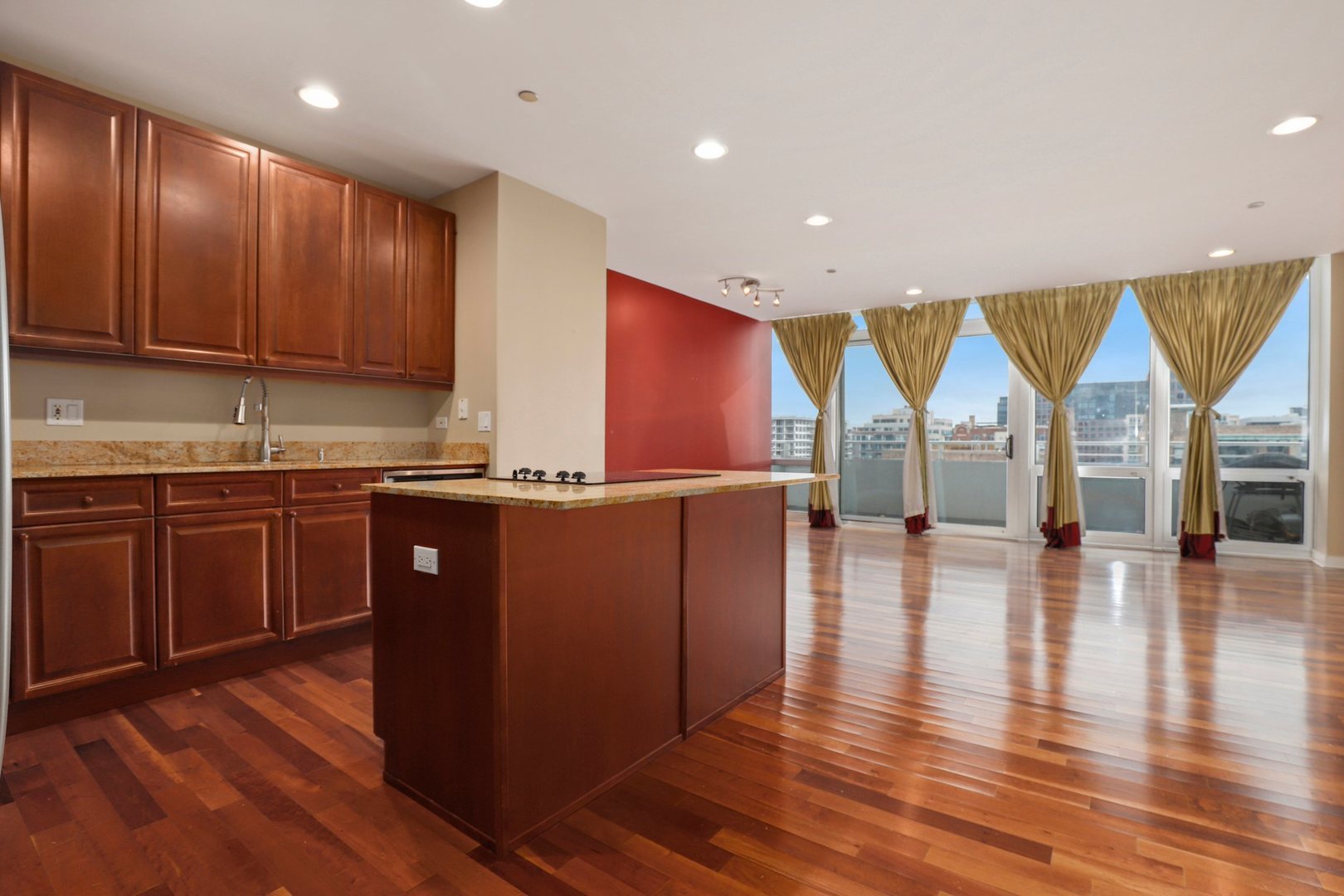 737 West Washington Boulevard, Unit 710 Chicago, IL 60661 - Photo 6 of 28 an open kitchen with kitchen island granite countertop wooden floors and a view of living room