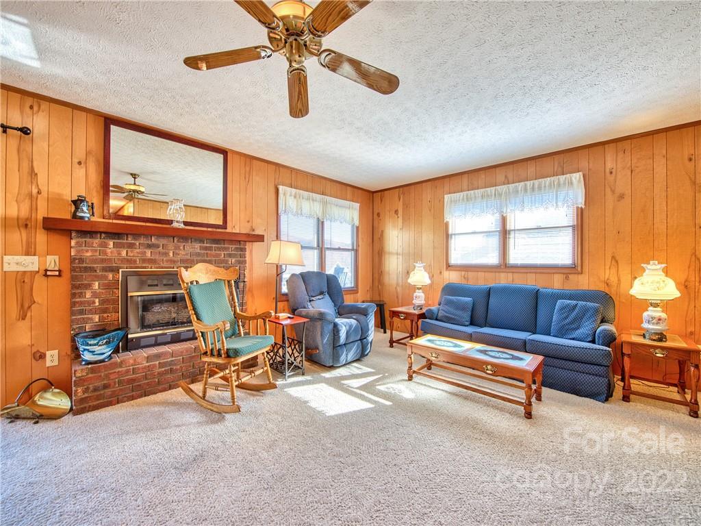 352 Stoney Ridge Loop Maggie Valley, NC 28751 - Photo 11 of 26 a living room with furniture a fireplace and a window