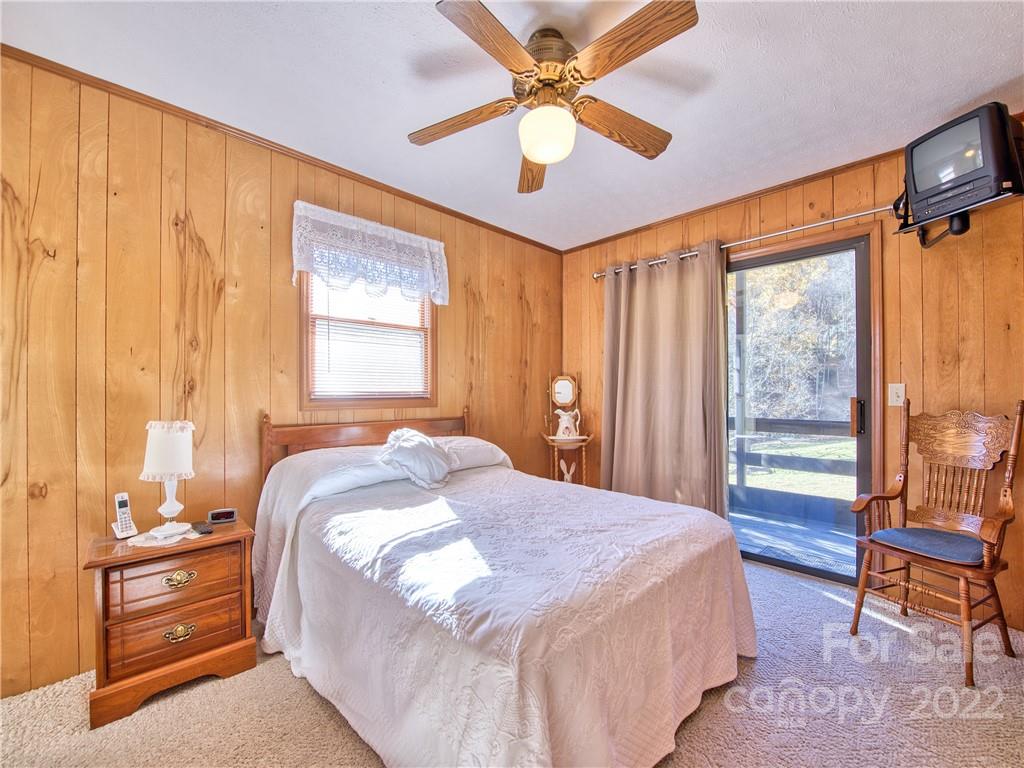 352 Stoney Ridge Loop Maggie Valley, NC 28751 - Photo 20 of 26 a bedroom with a large bed and a chandelier