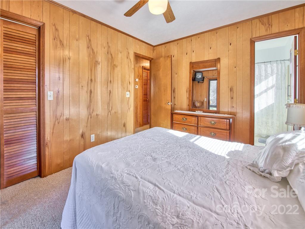 352 Stoney Ridge Loop Maggie Valley, NC 28751 - Photo 21 of 26 a bedroom with a bed and a chandelier