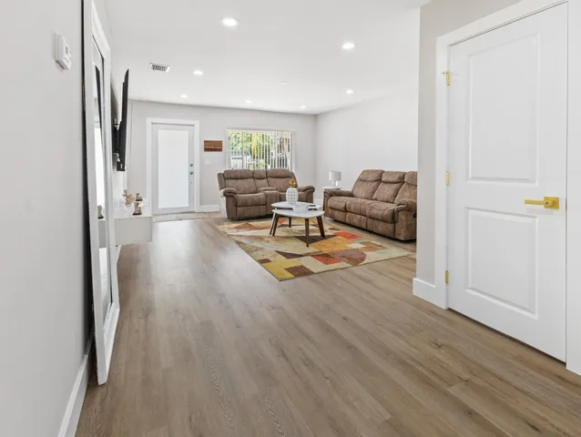 a living room with furniture and a wooden floor