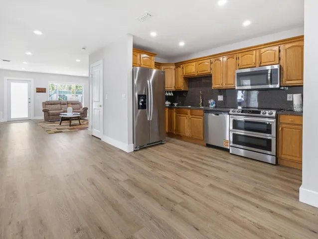 a kitchen with stainless steel appliances a refrigerator and a stove top oven