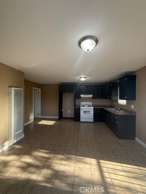 1232 East 68th Street Los Angeles, CA 90001 - Photo 3 of 5 a large kitchen with stainless steel appliances kitchen island granite countertop a sink and cabinets