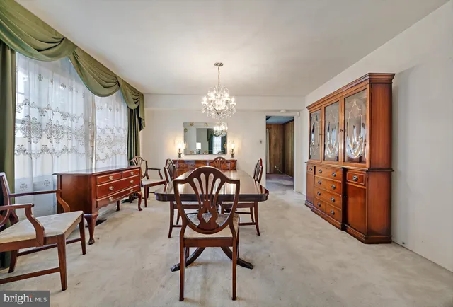 a view of a dining room with furniture and a chandelier