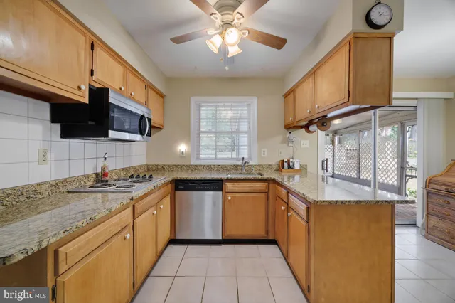 a kitchen with stainless steel appliances granite countertop a sink a stove and cabinets