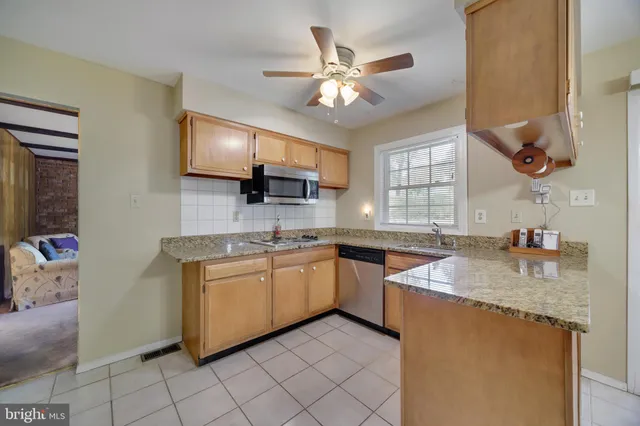 a kitchen with stainless steel appliances granite countertop a refrigerator a stove a sink and dishwasher