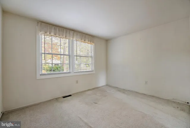 an empty room with windows and cabinet