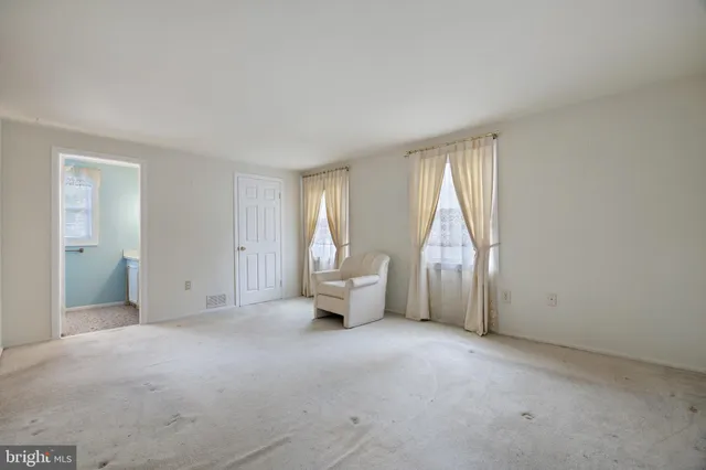 a view of empty room with wooden floor and iron fence