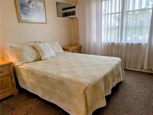 a bed sitting in a bedroom next to a window