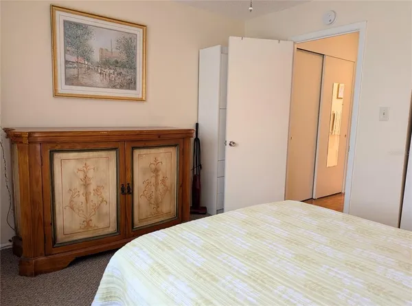 a bedroom with a bed and a painting on the wall