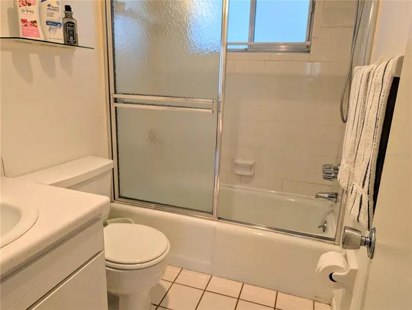 a bathroom with a granite countertop bathtub shower sink and toilet