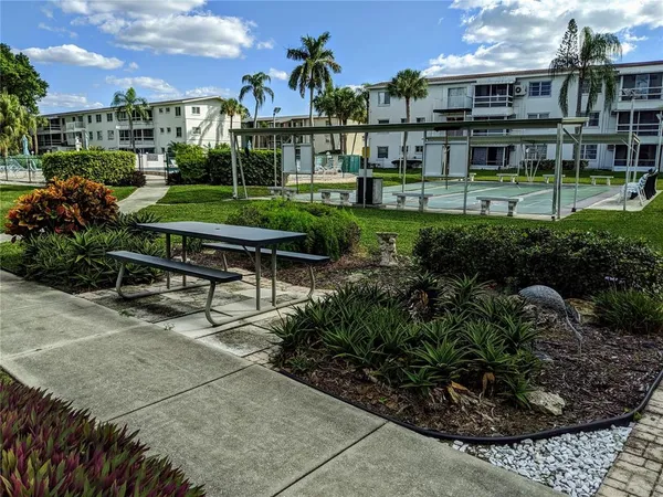 a garden with a bench in front of the house