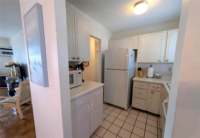 a kitchen with a refrigerator sink stove and cabinets