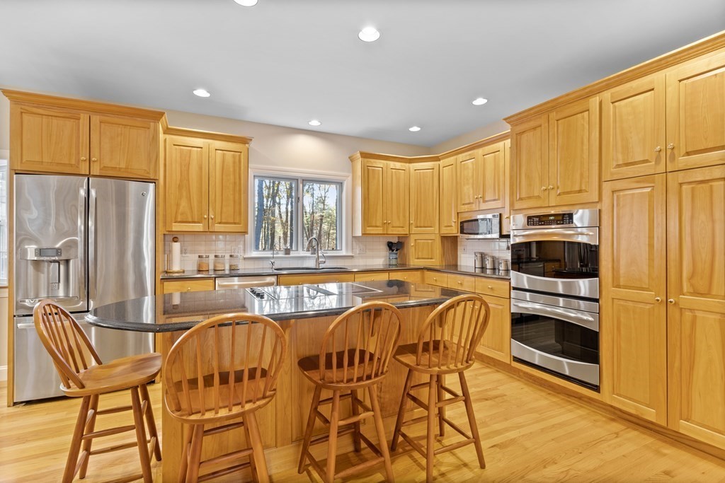 136 Hartwell Road Carlisle, MA 01741 - Photo 11 of 42 a kitchen with stainless steel appliances a stove a sink a microwave a refrigerator and cabinets