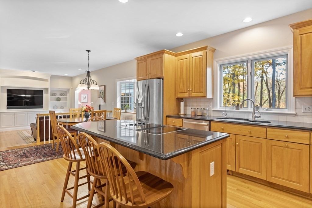 136 Hartwell Road Carlisle, MA 01741 - Photo 12 of 42 a kitchen with stainless steel appliances granite countertop a stove a sink a oven a dining table and chairs with wooden floor