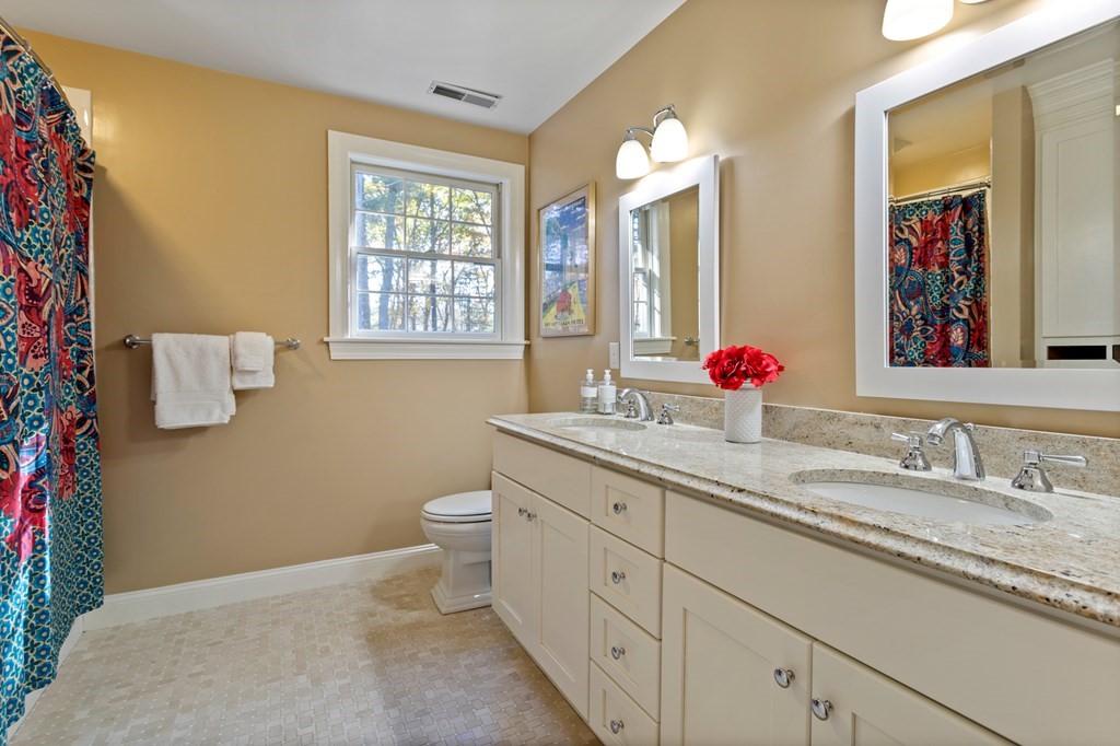 136 Hartwell Road Carlisle, MA 01741 - Photo 32 of 42 a bathroom with a granite countertop toilet sink and mirror