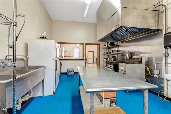 a kitchen with a refrigerator and a stove top oven
