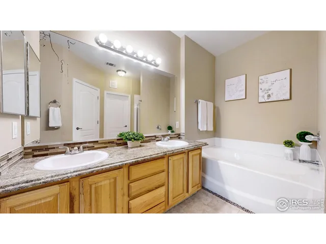 a bathroom with a tub a sink and mirror