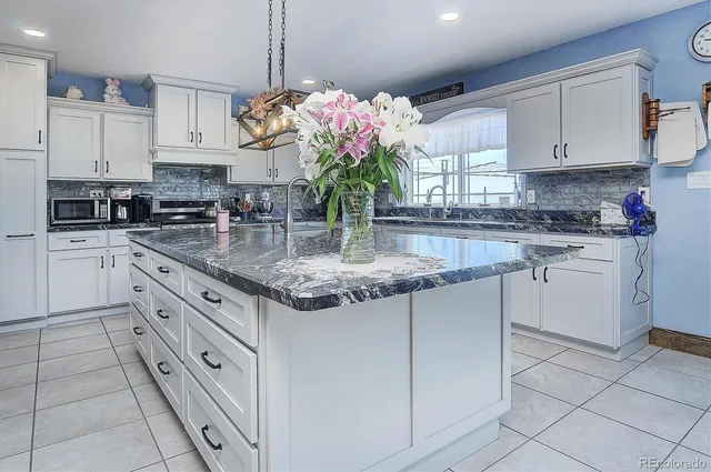 a kitchen with stainless steel appliances granite countertop a sink a stove and cabinets