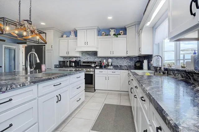 a kitchen with granite countertop white cabinets and white appliances